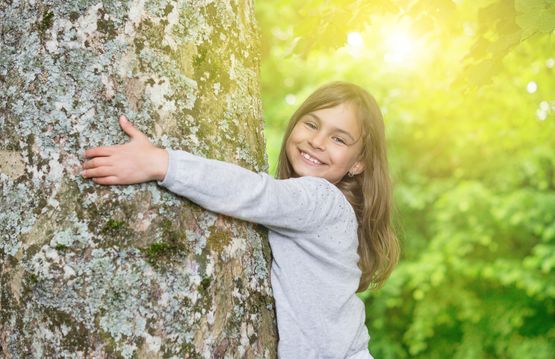 Mädchen umarmt Baum